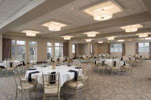 um salão de banquetes com mesas e cadeiras brancas em Courtyard by Marriott Lake George em Lake George
