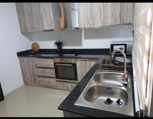 阿克拉的住宿－LV Appartment x Airport Residential Area，厨房配有水槽和炉灶