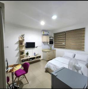 a bedroom with a bed and a desk and a tv at LV Appartment x Airport Residential Area in Accra