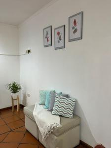 Habitación blanca con sofá y almohadas. en Piso 1 en Merlo