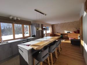 eine Küche mit einem langen Tisch und einigen Fenstern in der Unterkunft Luxury chalet in Tauplitz Styria with sauna and swimming pond in Bad Mitterndorf