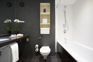 a bathroom with a toilet and a sink and a tub at Crowne Plaza London - Docklands, an IHG Hotel in London