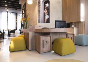 a lobby with a desk with a tv and colorful chairs at PH Hotel Oosteinde in Amsterdam