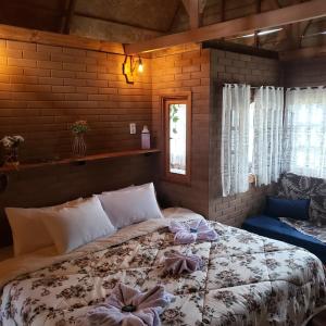 a bedroom with a bed with bows on it at Pousada Grom's Village in Campos do Jordão