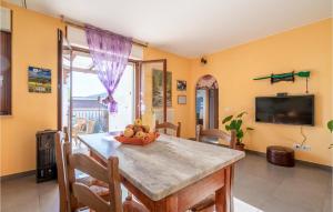 uma sala de jantar com uma mesa com uma taça de fruta em Stunning Apartment In Cologna Spiaggia With Wifi em LʼAnnunziata