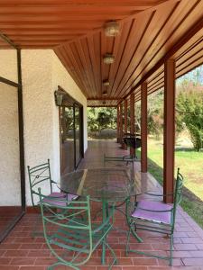 une table et des chaises en verre sur la terrasse dans l'établissement Casa tranquila y central con piscina en Olmué, à Olmué