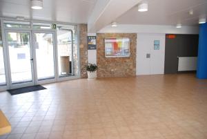 a large empty room with a tile floor and glass doors at Alberg L'Escala Xanascat in L'Escala