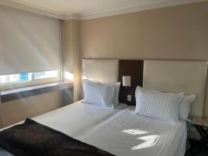 1 dormitorio con 1 cama grande con sábanas y almohadas blancas en Transamerica Al Santos981, en São Paulo