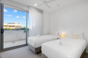 two beds in a room with a large window at Rise Maroochydore in Maroochydore +73 photos