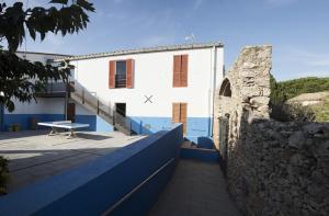 a white building with a wall next to it at Alberg L'Escala Xanascat in L'Escala
