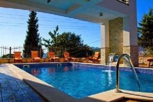 a large swimming pool with orange chairs in a house at Villa M in Dobra Voda