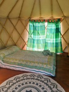 Cama en yurta con ventana y alfombra en Terra Cristal, en Piriápolis