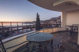 a balcony with a table and a view of the ocean at Villa M in Dobra Voda