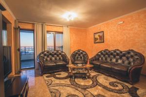 a living room with two leather couches and a table at Villa M in Dobra Voda