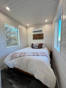 um quarto com uma cama num quarto com uma janela em NEW The Flagship 2 Story Container Home em Waco