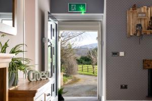 una puerta abierta con un letrero de salida verde en la pared en Swn y Cnocell, en Y Felinheli
