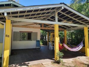 une pergola avec un hamac sur une maison dans l'établissement Casa Praia da Barra, Garopaba, à Garopaba