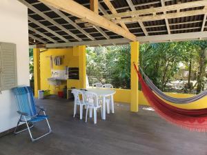 Habitación con hamaca, mesa y sillas. en Casa Praia da Barra, Garopaba, en Garopaba