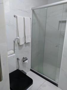 y baño con ducha, aseo y toallas. en Bahia Flat localização excelente, en Salvador