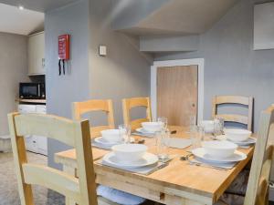 uma mesa de madeira com pratos e tigelas em Barncailzie Lodge em Kirkpatrick Durham