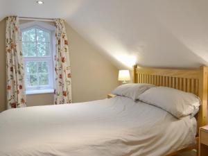 Kirkpatrick DurhamにあるBarncailzie Lodgeのベッドルーム(白いベッド1台、窓付)