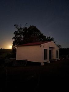 ein kleines weißes Haus mit einem Baum im Hintergrund in der Unterkunft Casa en Villa Serrana para 4 personas. in Villa Serrana