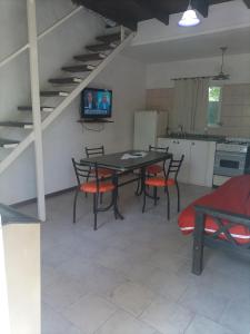 una sala da pranzo con tavolo e sedie e una cucina di Las moras a Chascomús