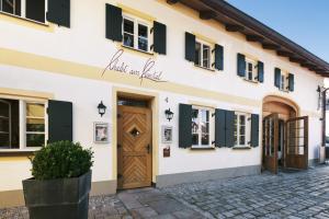 um edifício com uma porta de madeira e janelas em Romantik Hotel Chalet am Kiental em Herrsching am Ammersee
