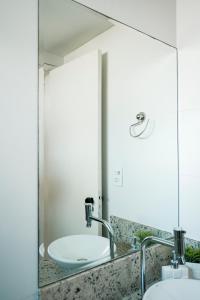 een badkamer met 2 wastafels en een grote spiegel bij Praia da Costa 2 Quartos com Suite Clássico in Vila Velha