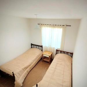 Duas camas num quarto com uma janela em Kau hostel & experiencias em Perito Moreno