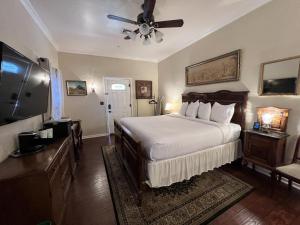 a bedroom with a large bed with a ceiling fan at El Amador Downtown Luxury Inn in Tucson