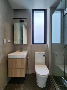 La salle de bains est pourvue de toilettes, d'un lavabo et d'un miroir. dans l'établissement Stay Max Apartment for Perfect Short Stay, à Auckland