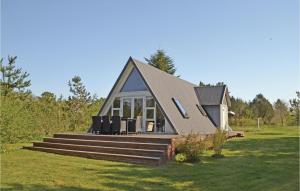 a small house with a pitched roof on a field at Gorgeous Home In Lgstr With Wifi in Løgstør