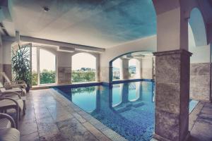 a large swimming pool in a building with windows at Hotel Azimut in Sveti Stefan
