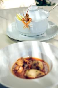 two plates of food on a table with a bowl of food at Hotel Azimut in Sveti Stefan