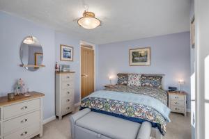 a bedroom with a bed and a chair and a mirror at The Old Laundry in Horsham Saint Faith