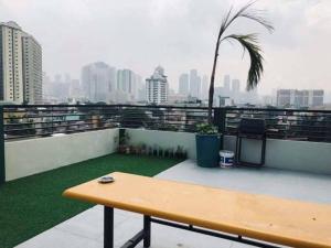een houten bank op een balkon met uitzicht op de stad bij Adorable Lounge - 1 Bedroom loft w/home cinema in Manilla