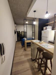 a kitchen with a counter and two stools in it at Departamento - Salta Capital sm - Edificio Usina in Salta