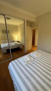 1 dormitorio con 1 cama grande y espejo grande en Il Riposo en Salta