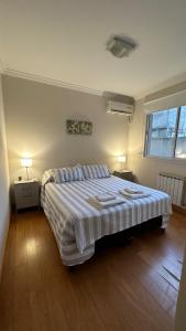 1 dormitorio con 1 cama grande, 2 mesas y 2 lámparas en Il Riposo en Salta
