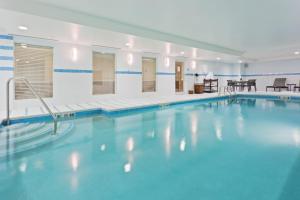 a swimming pool with blue water in a building at Holiday Inn Express - Neptune, an IHG Hotel in Neptune City
