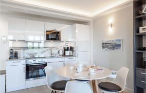 a kitchen with white cabinets and a table and chairs at Princess in Binz