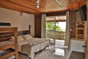 um quarto com um beliche e uma varanda em Pousada Beira Mar na Ilha do Mel