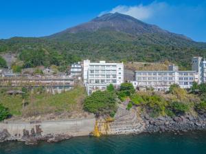 Blick auf eine Stadt mit einem Berg im Hintergrund in der Unterkunft Sakurajima Seaside Hotel in Sakurajima