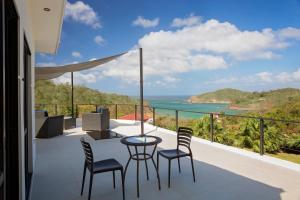 balcón con mesa, sillas y vistas al océano en Casa Oli Mar en San Juan del Sur