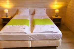 two beds in a room with two lamps on tables at Comfortable cottages, very close to the sea, G ski in Gąski