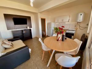 cocina y comedor con mesa y sillas en Departamento Monte Olivia en Ushuaia