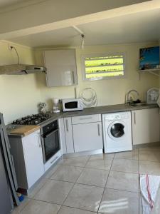 a kitchen with white appliances and a stove top oven at Goyave-Cerise in Trois-Rivières