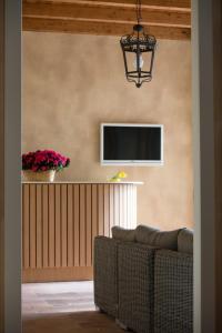 sala de estar con sofá y TV en la pared en Agriturismo La Galizia, en Cuggiono