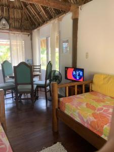 sala de estar con cama y TV. en Cabo tortuga bungalows en Monterrico